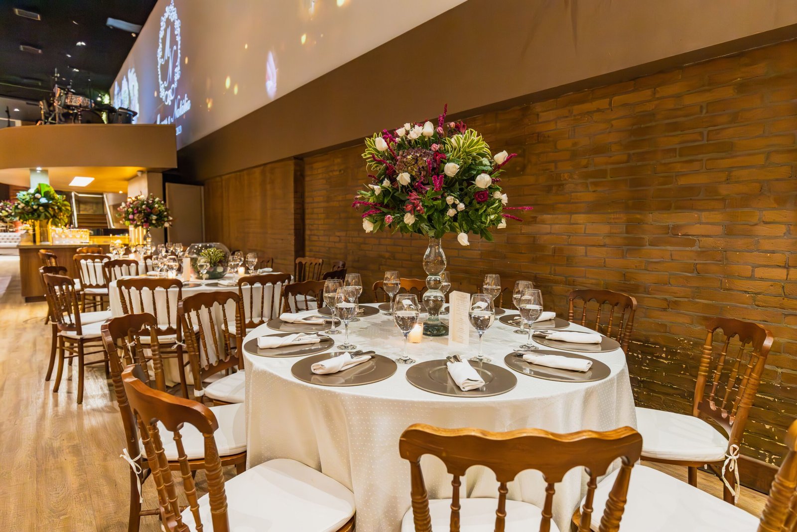 Luxurious indoor dining setup with decorated tables for a wedding reception.